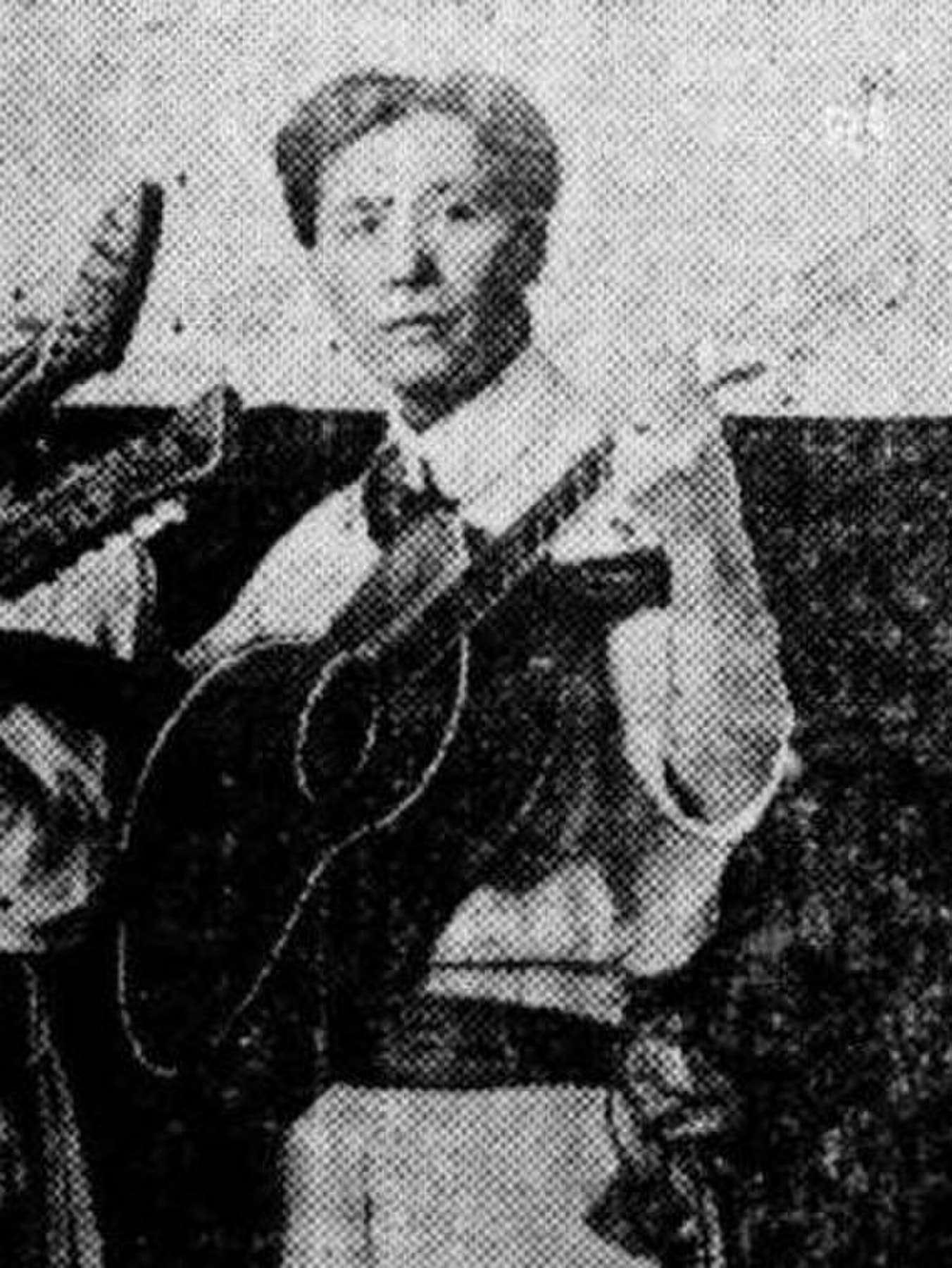 Black-and-white portrait of Joseph Kekuku holding a Hawaiian steel guitar.