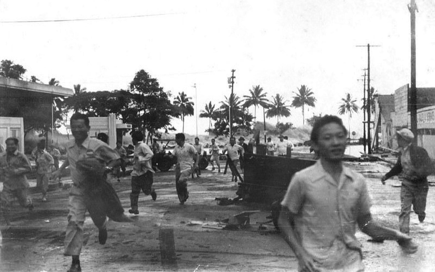 Black-and-white view of a large tsunami wave advancing toward Hilo in 1946.